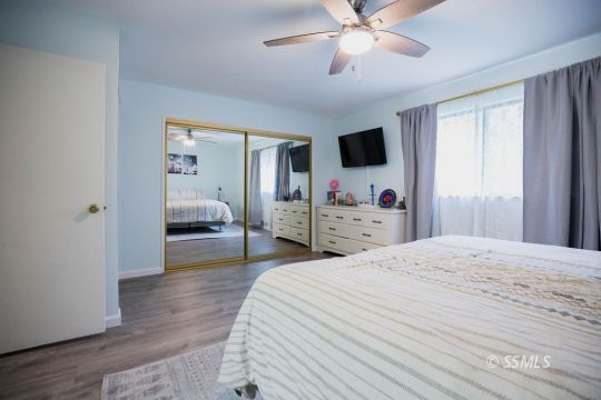 199 East Upjohn Avenue Ridgecrest, CA 93555 - Photo 21 of 30 a bedroom with a bed and a chandelier