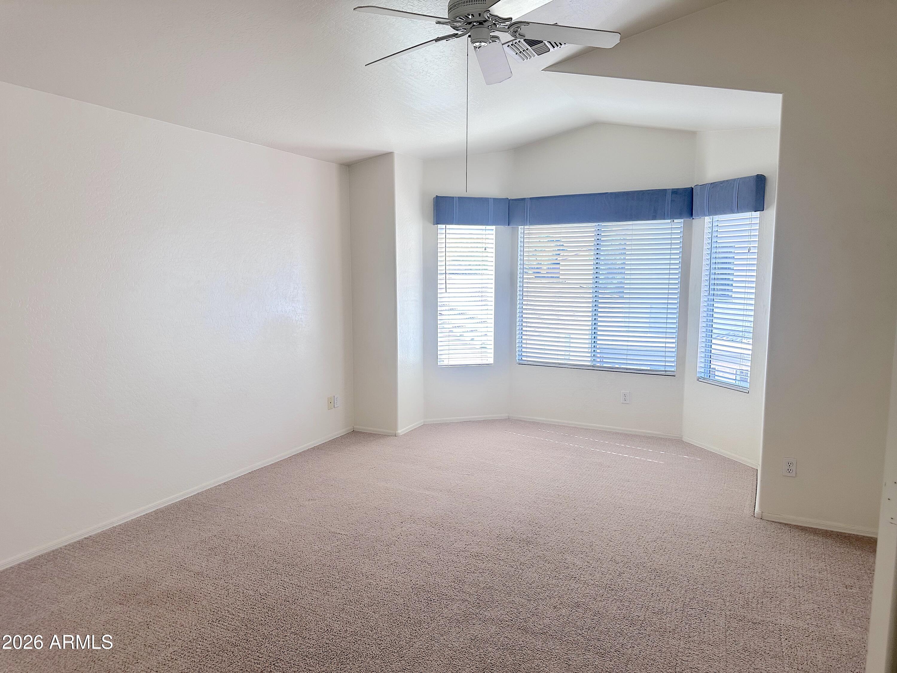 4106 East Chambers Street Phoenix, AZ 85040 - Photo 15 of 33 an empty room with a ceiling fan and windows