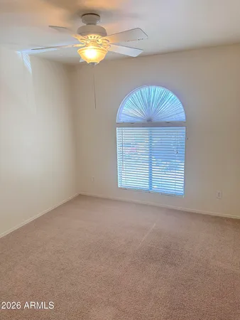 en empty room with windows and chandelier fan