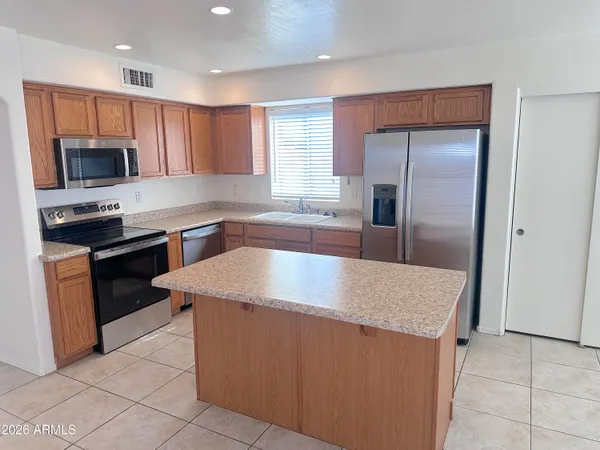 a kitchen with stainless steel appliances granite countertop a sink a refrigerator and a stove
