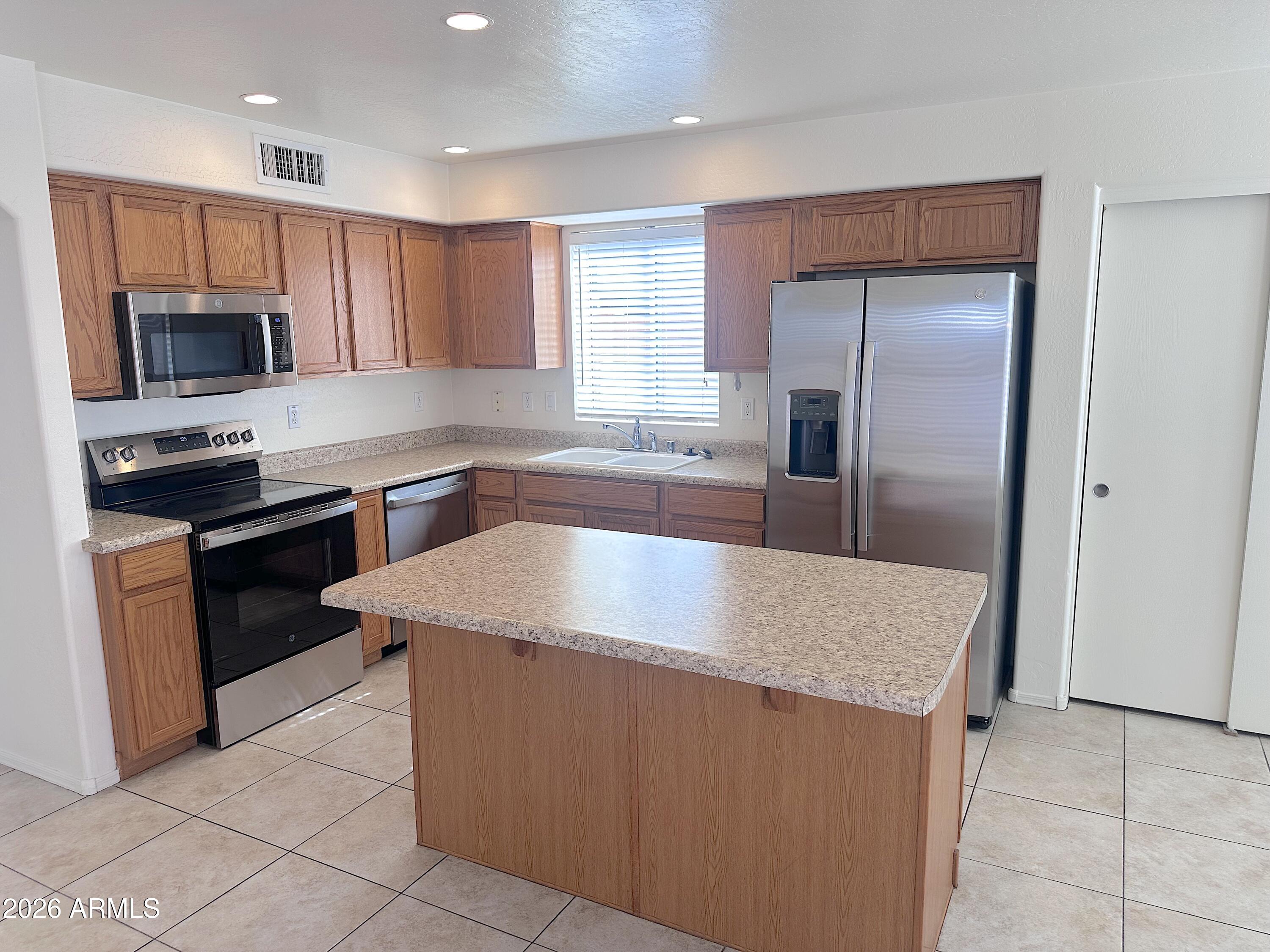 4106 East Chambers Street Phoenix, AZ 85040 - Photo 7 of 33 a kitchen with stainless steel appliances granite countertop a sink a refrigerator and a stove