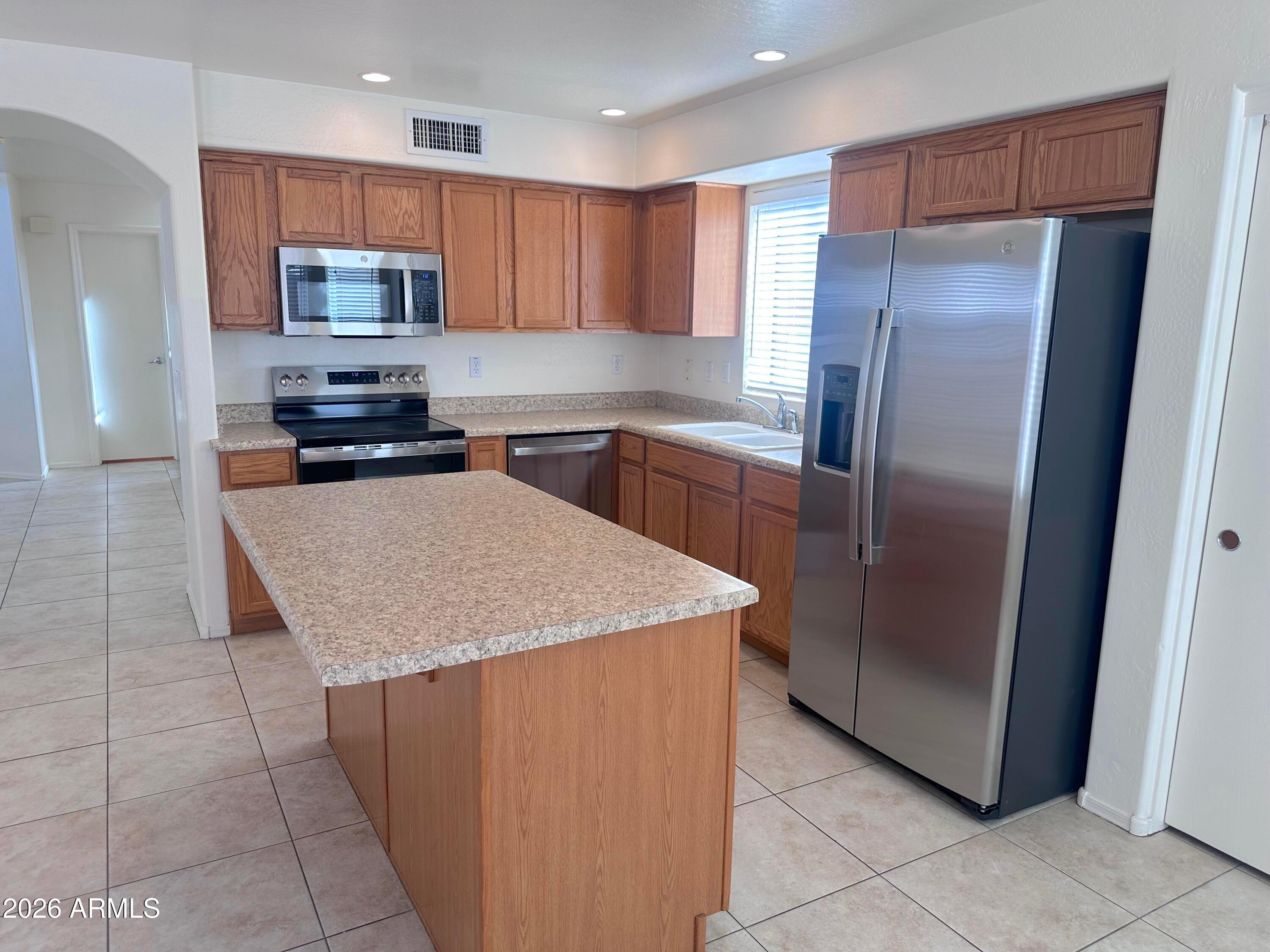 4106 East Chambers Street Phoenix, AZ 85040 - Photo 9 of 33 a kitchen with stainless steel appliances granite countertop a refrigerator a stove a sink and dishwasher