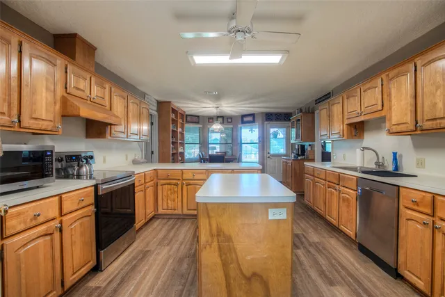 a kitchen with stainless steel appliances granite countertop a sink a stove and white cabinets