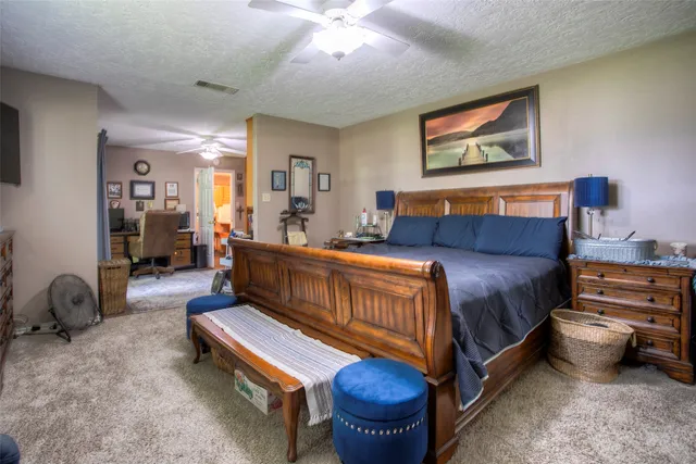 a spacious bedroom with a bed and dresser