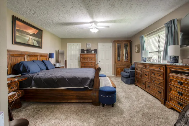 a bedroom with a bed couch tv and a window