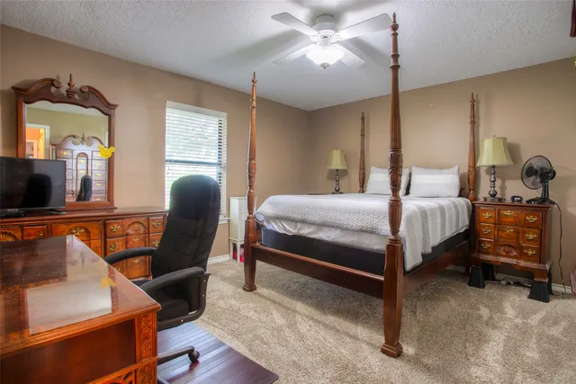 a bedroom with a bed a window and chair