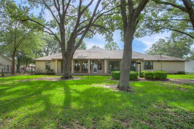 a view of a tiny house with a big yard and large trees