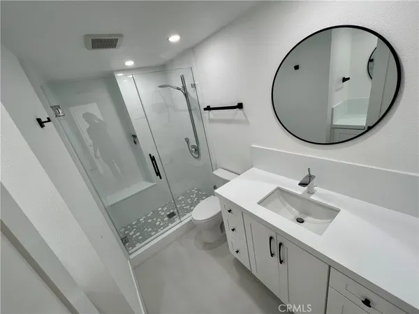 a bathroom with a sink a toilet and a mirror