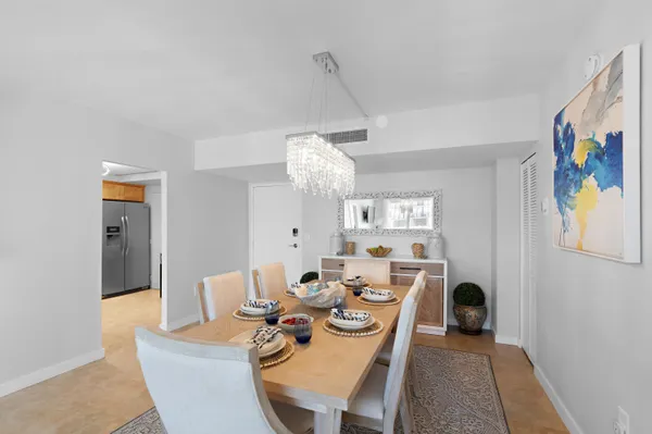 a kitchen with stainless steel appliances granite countertop a sink a stove a refrigerator a washer dryer and a dining table