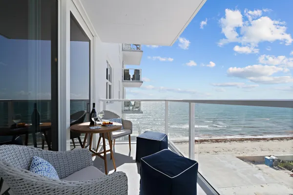 a balcony view with a dining table and chairs with wooden floor