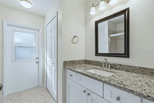 a bathroom with a granite countertop sink vanity and mirror
