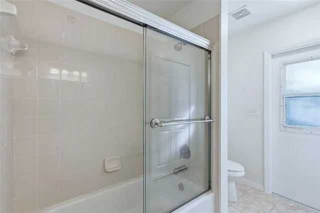 a bathroom with a granite countertop bathtub shower and toilet