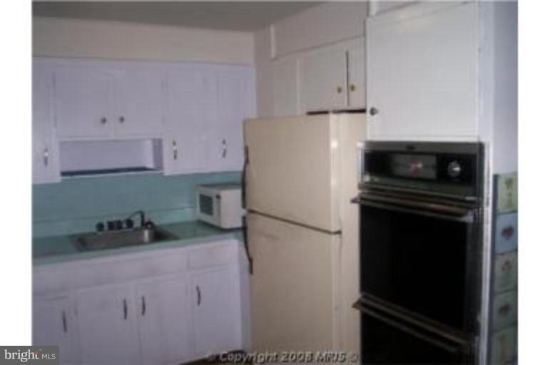 7384 Edsworth Road Dundalk, MD 21222 - Photo 3 of 6 a white refrigerator freezer sitting in a kitchen