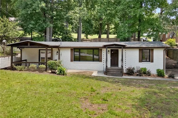 a view of a house with backyard and sitting area
