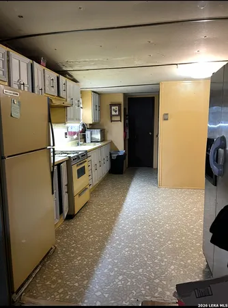 a kitchen with refrigerator and cabinets