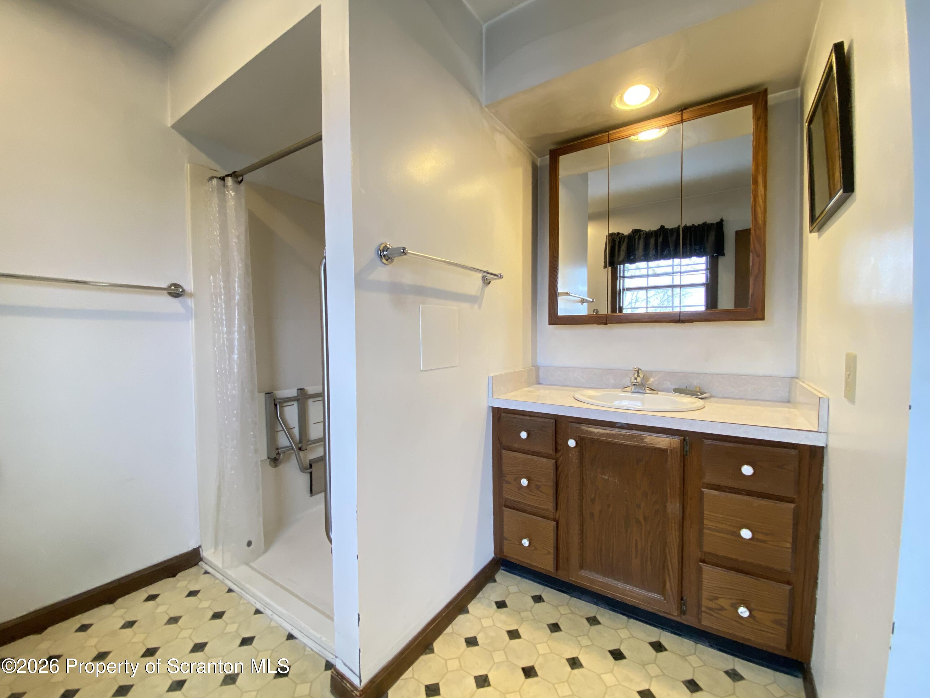 1303 Ridgewood Avenue Scranton, PA 18505 - Photo 19 of 57 a bathroom with a sink mirror and a shower
