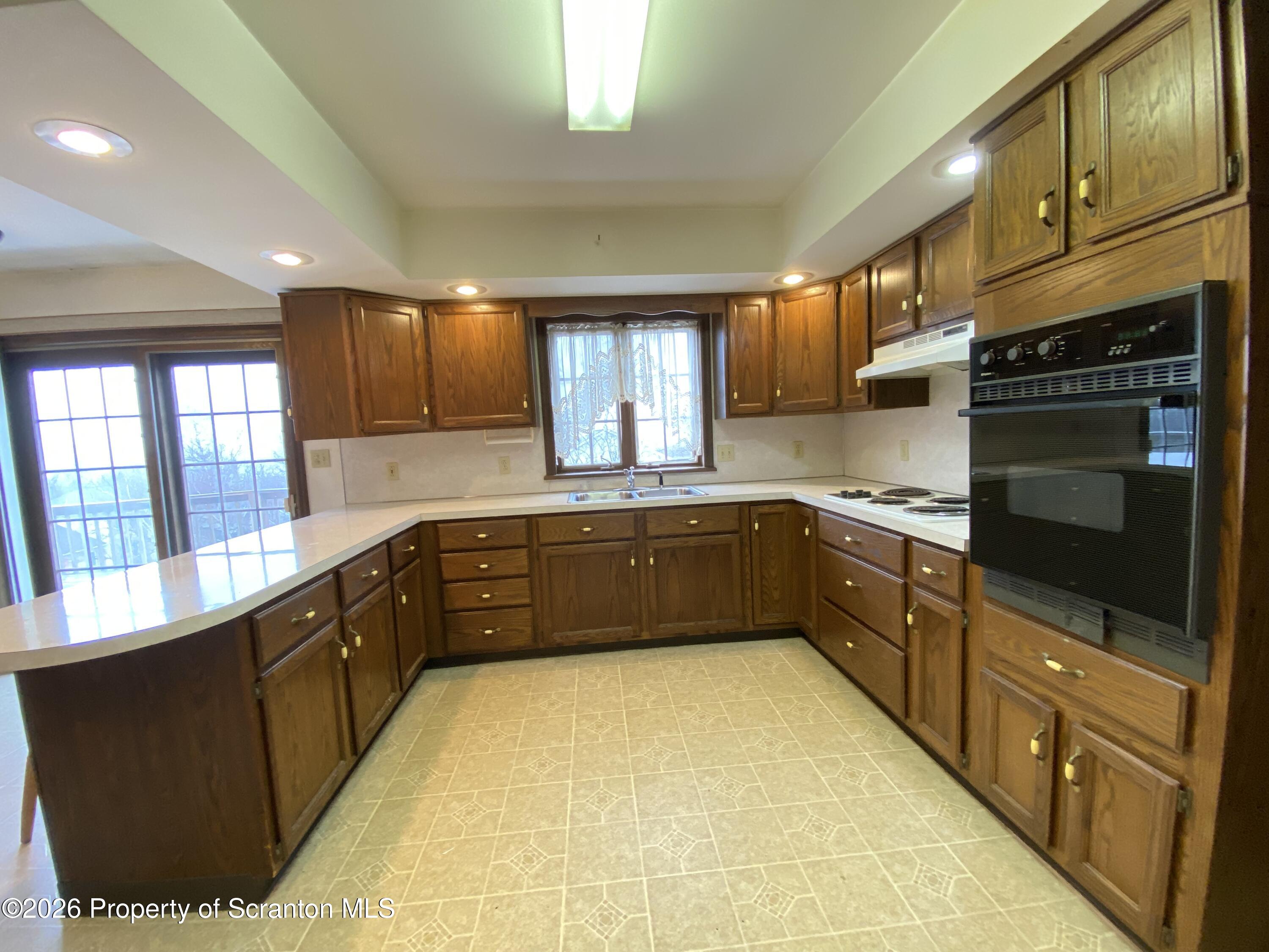 1303 Ridgewood Avenue Scranton, PA 18505 - Photo 9 of 57 a kitchen with stainless steel appliances granite countertop a sink counter space cabinets and a large window