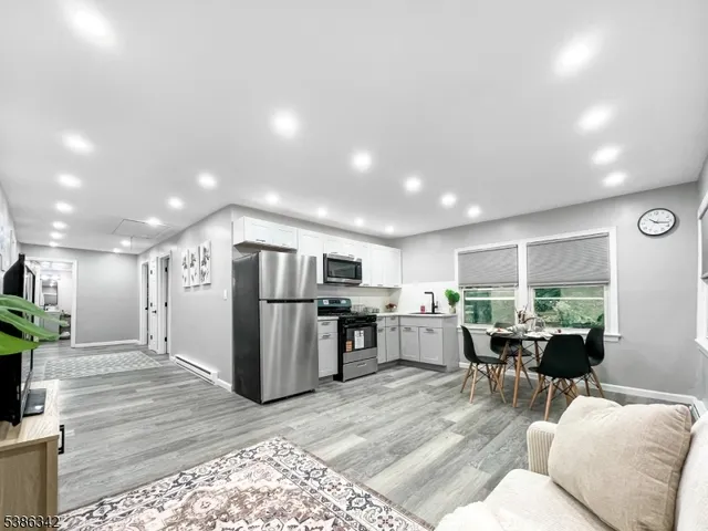 a living room with furniture a large window with kitchen view