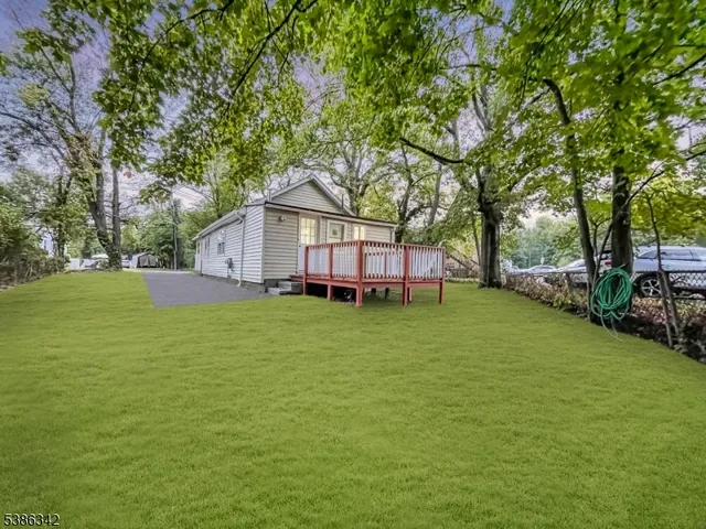 a front view of a house with a garden and trees