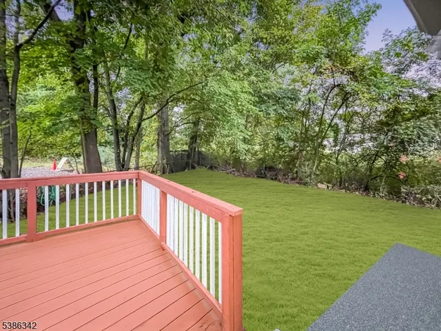 a view of a wooden deck and yard with green space