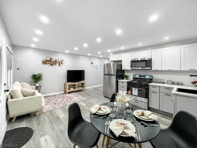 a kitchen with stainless steel appliances kitchen island granite countertop a dining table and chairs