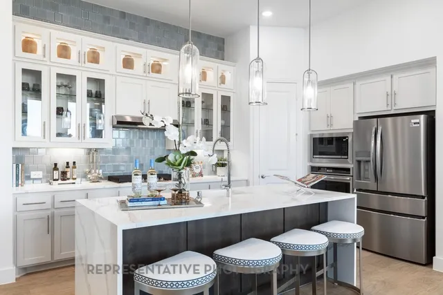 a living room with furniture kitchen view and a chandelier
