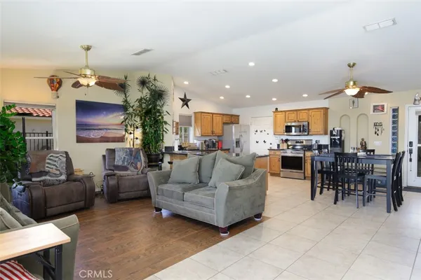 a living room with furniture kitchen view and a chandelier