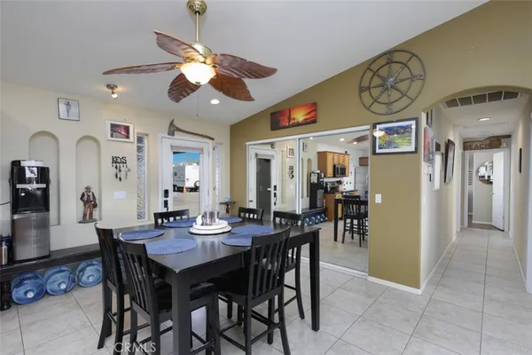a dining room with wooden floor a chandelier a wooden table and chairs