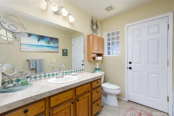 a bathroom with a granite countertop toilet sink and mirror