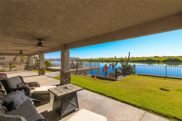 a view of a patio with lawn chairs kitchen view and a ocean view