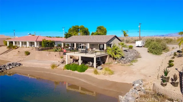 a front view of a house with a yard and palm trees