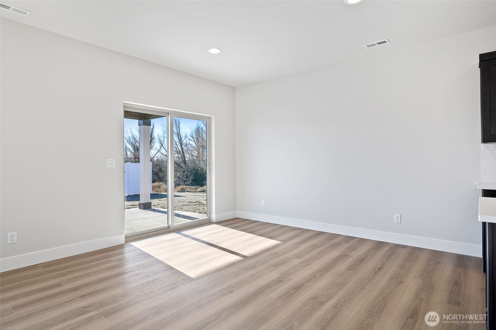 4247 Sandy Street Moses Lake, WA 98837 - Photo 9 of 24 an empty room with wooden floor and windows