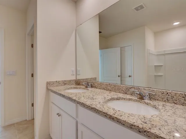 a bathroom with a granite countertop sink and a mirror