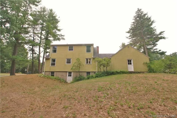 a view of a house with a large tree and a yard