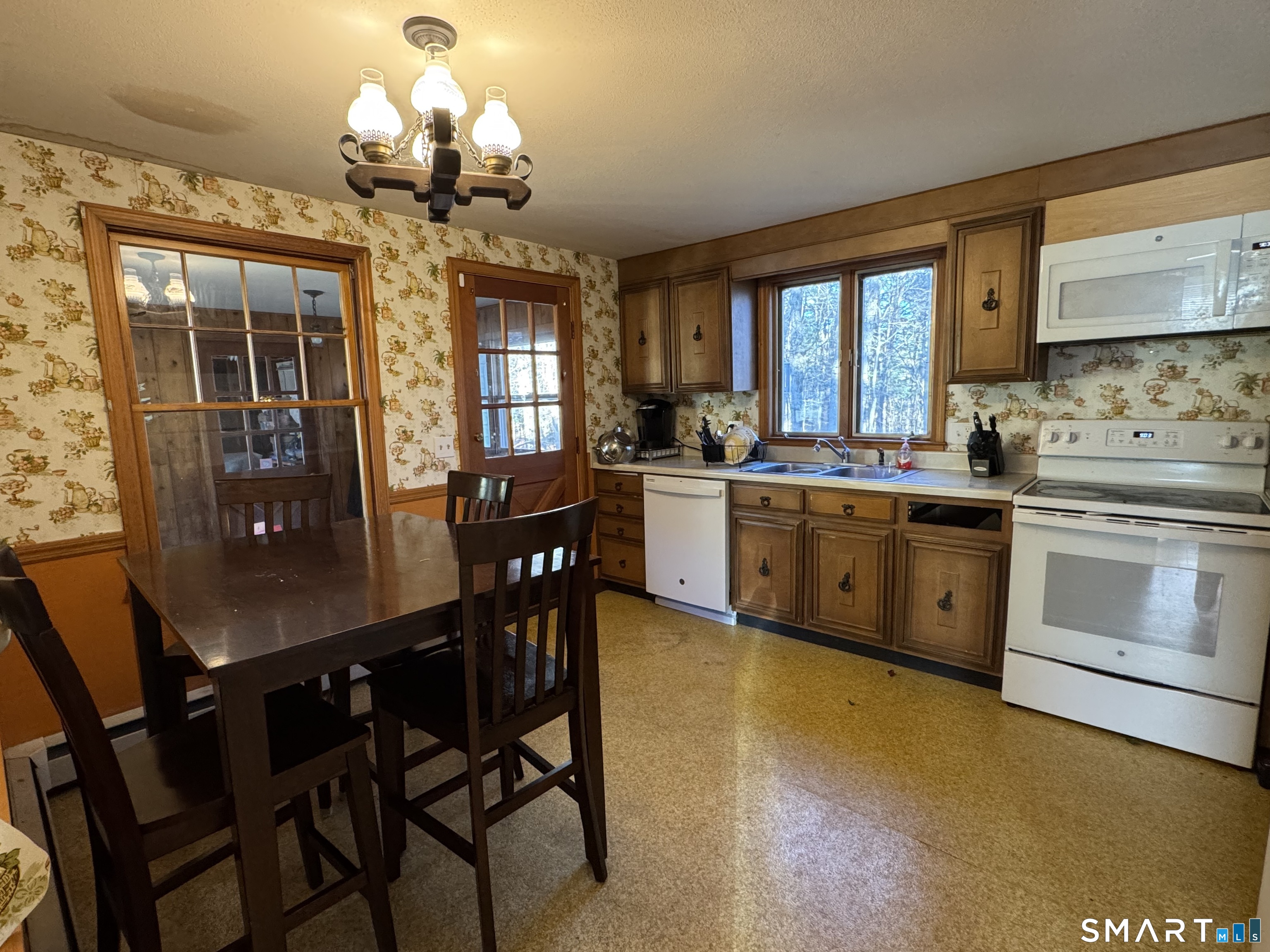404 Woodland Street Windsor Locks, CT 06096 - Photo 5 of 8 a kitchen with stainless steel appliances granite countertop a stove a refrigerator a dining table and chairs with wooden floor
