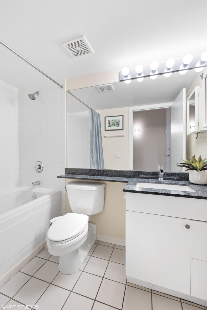 500 South Clinton Street, Unit 722 Chicago, IL 60607 - Photo 13 of 21 a bathroom with a toilet a sink a mirror a bathtub and vanity