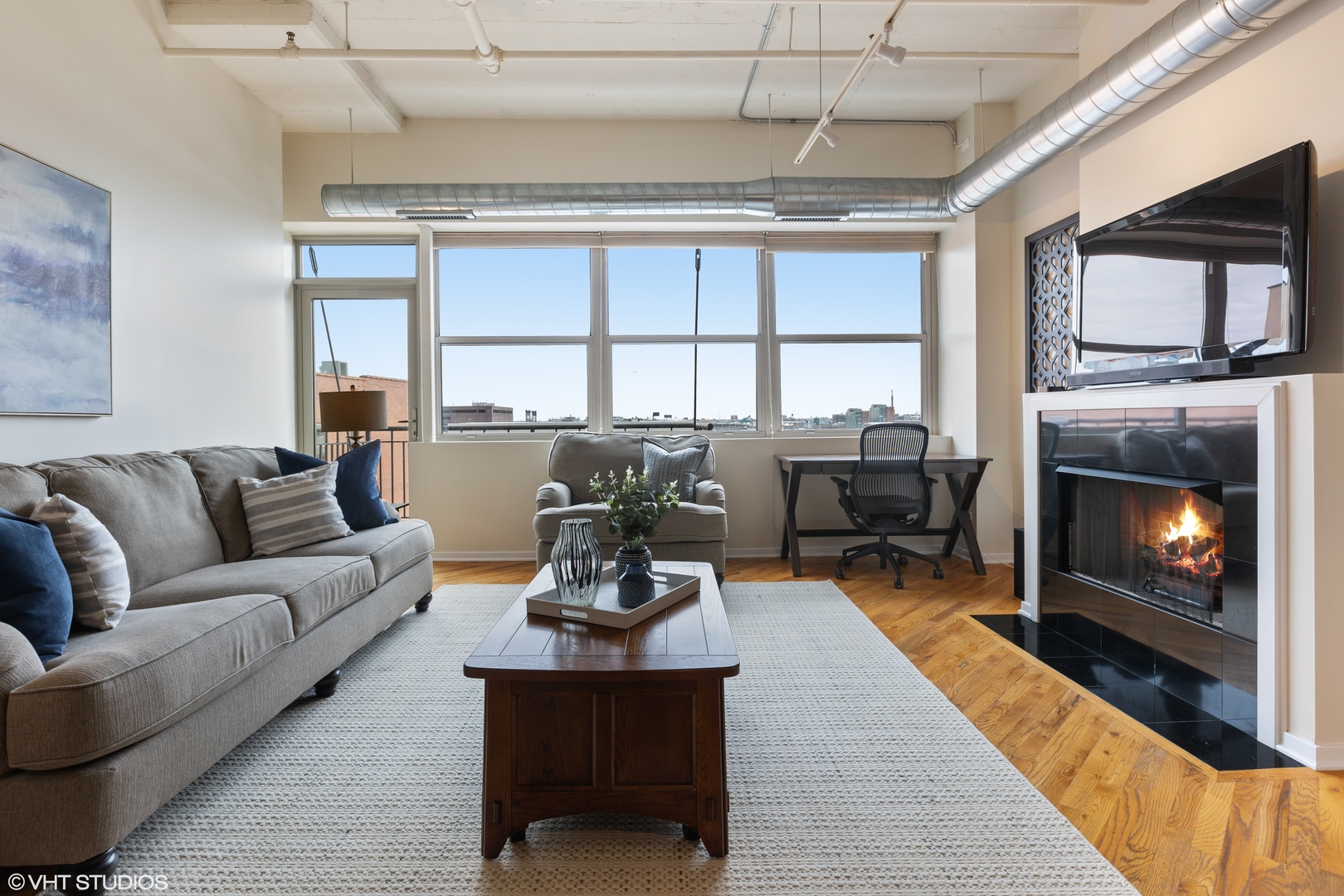 500 South Clinton Street, Unit 722 Chicago, IL 60607 - Photo 2 of 21 a living room with furniture a fireplace and a flat screen tv