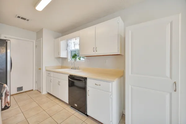 a kitchen with granite countertop white cabinets and white appliances