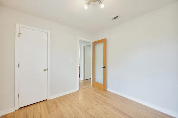a view of an empty room with wooden floor