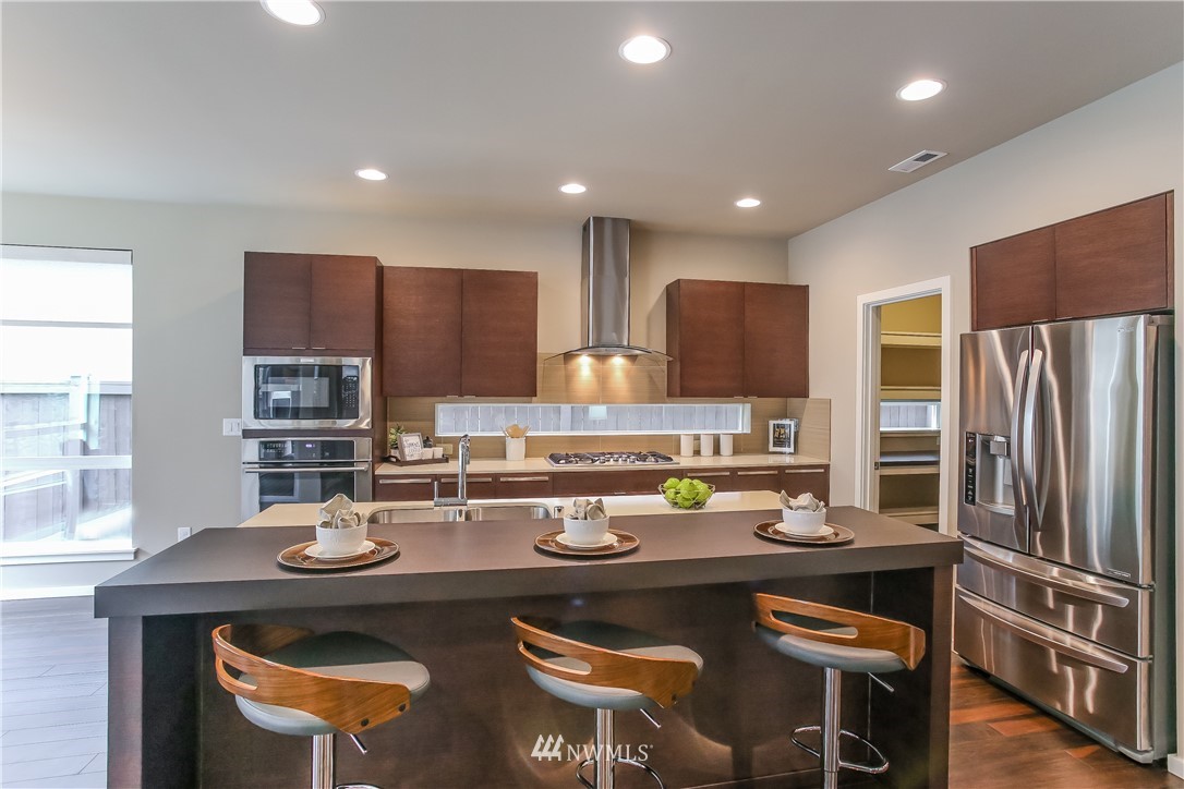4108 168th Place Southeast Bothell, WA 98012 - Photo 6 of 39 a kitchen with refrigerator a sink and chairs