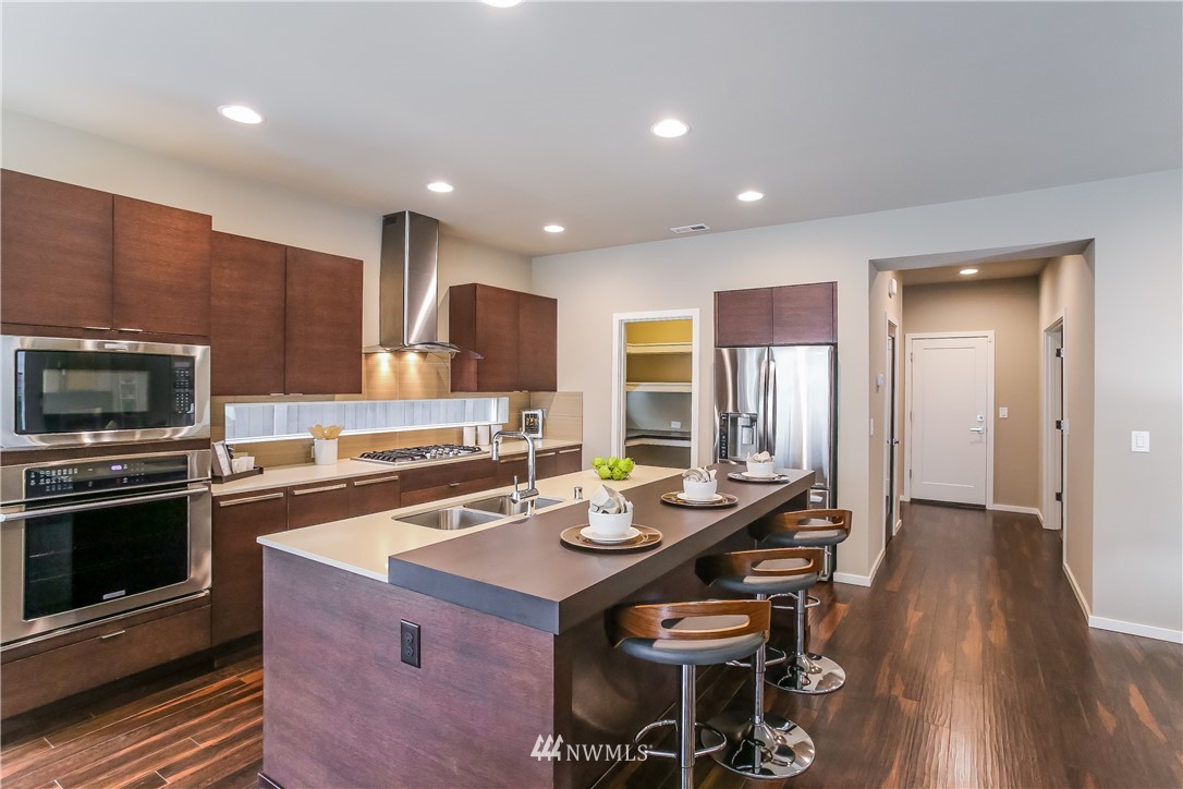 4108 168th Place Southeast Bothell, WA 98012 - Photo 8 of 39 a kitchen with stainless steel appliances kitchen island granite countertop a stove a sink a refrigerator and a microwave