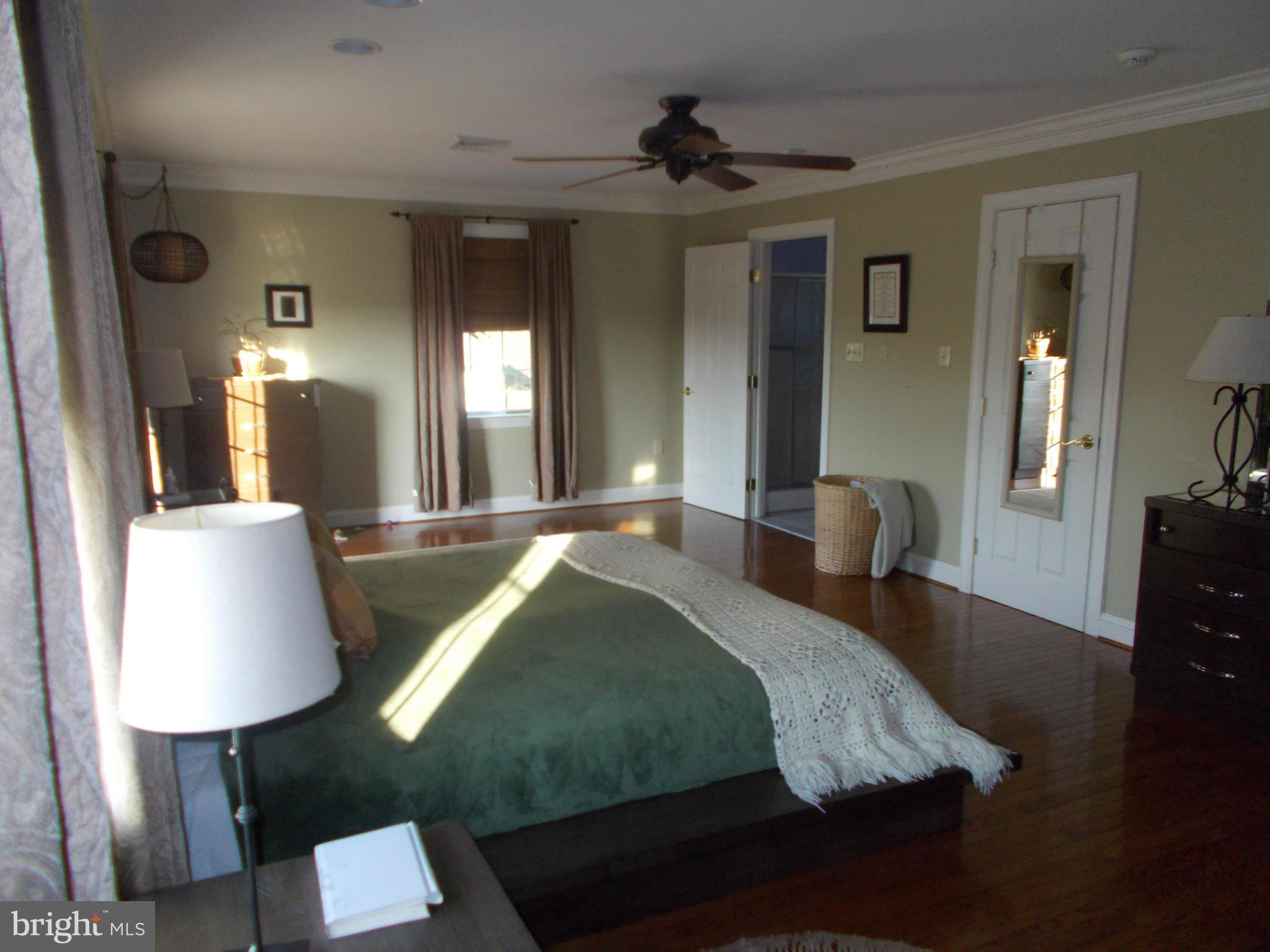15712 Spade Road Hagerstown, MD 21740 - Photo 12 of 30 a spacious bedroom with a bed and a lamp on table