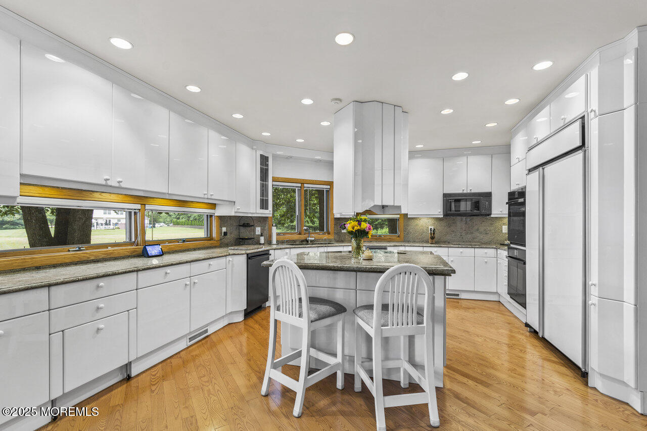 31 Thompson Grove Road Freehold, NJ 07728 - Photo 18 of 54 a kitchen with stainless steel appliances kitchen island granite countertop a stove a sink and a refrigerator