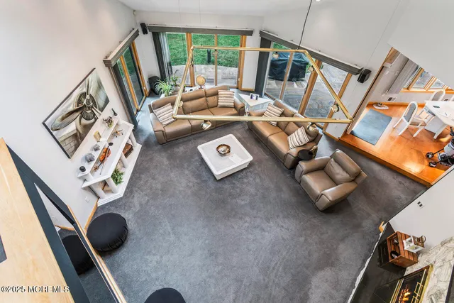 a view of a dining room with furniture a chandelier and a large window
