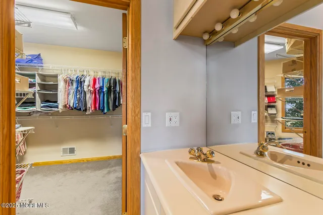 a spacious bathroom with a mirror and sink