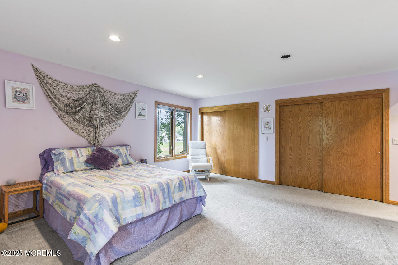 31 Thompson Grove Road Freehold, NJ 07728 - Photo 43 of 54 a bedroom with a large bed and a chandelier