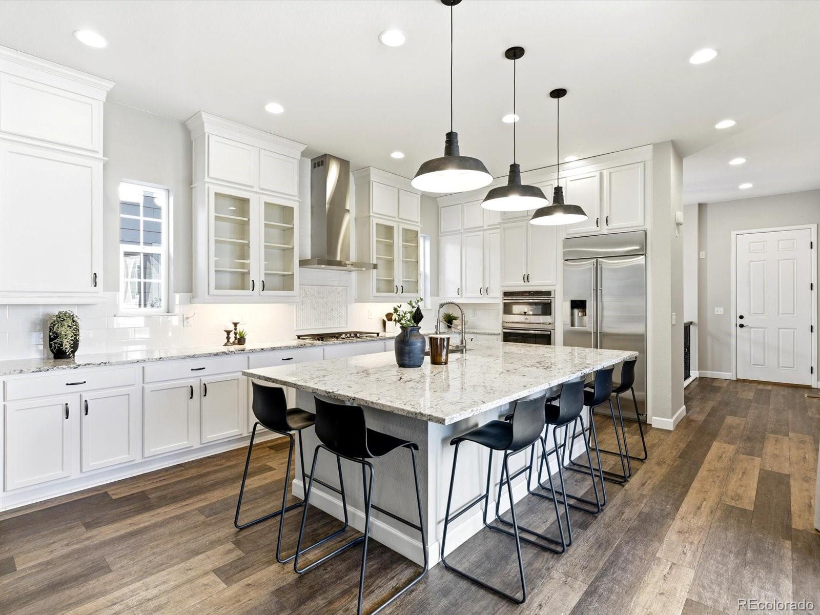 6579 South Vaughn Street Centennial, CO 80111 - Photo 3 of 44 a kitchen with stainless steel appliances kitchen island granite countertop a table chairs and a sink