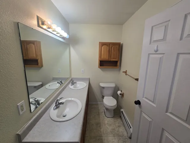a bathroom with a granite countertop toilet sink and mirror