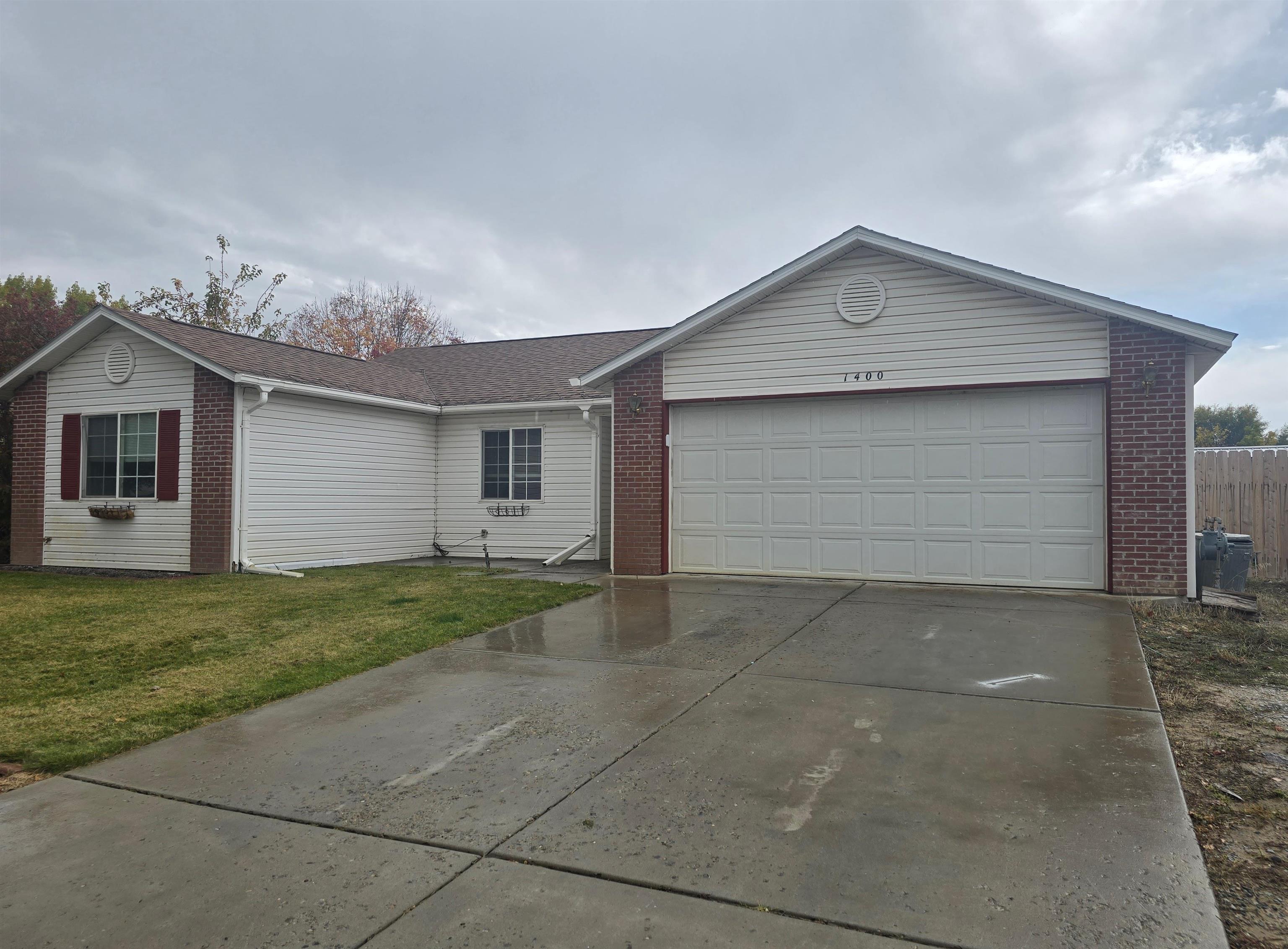 1400 Powell Street Fruita, CO 81521 - Photo 2 of 21 a front view of a house with a yard and garage