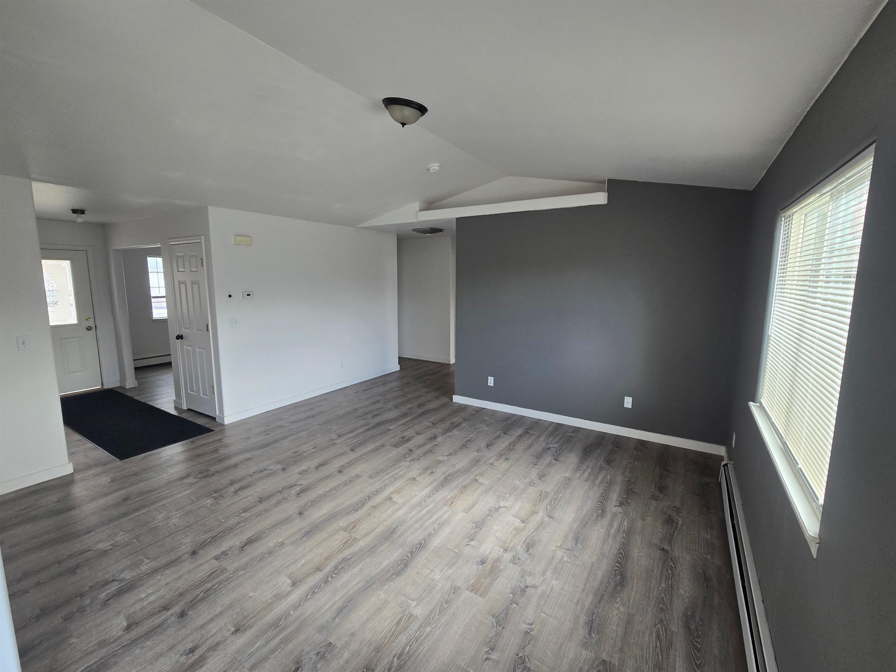 1400 Powell Street Fruita, CO 81521 - Photo 6 of 21 an empty room with wooden floor and windows